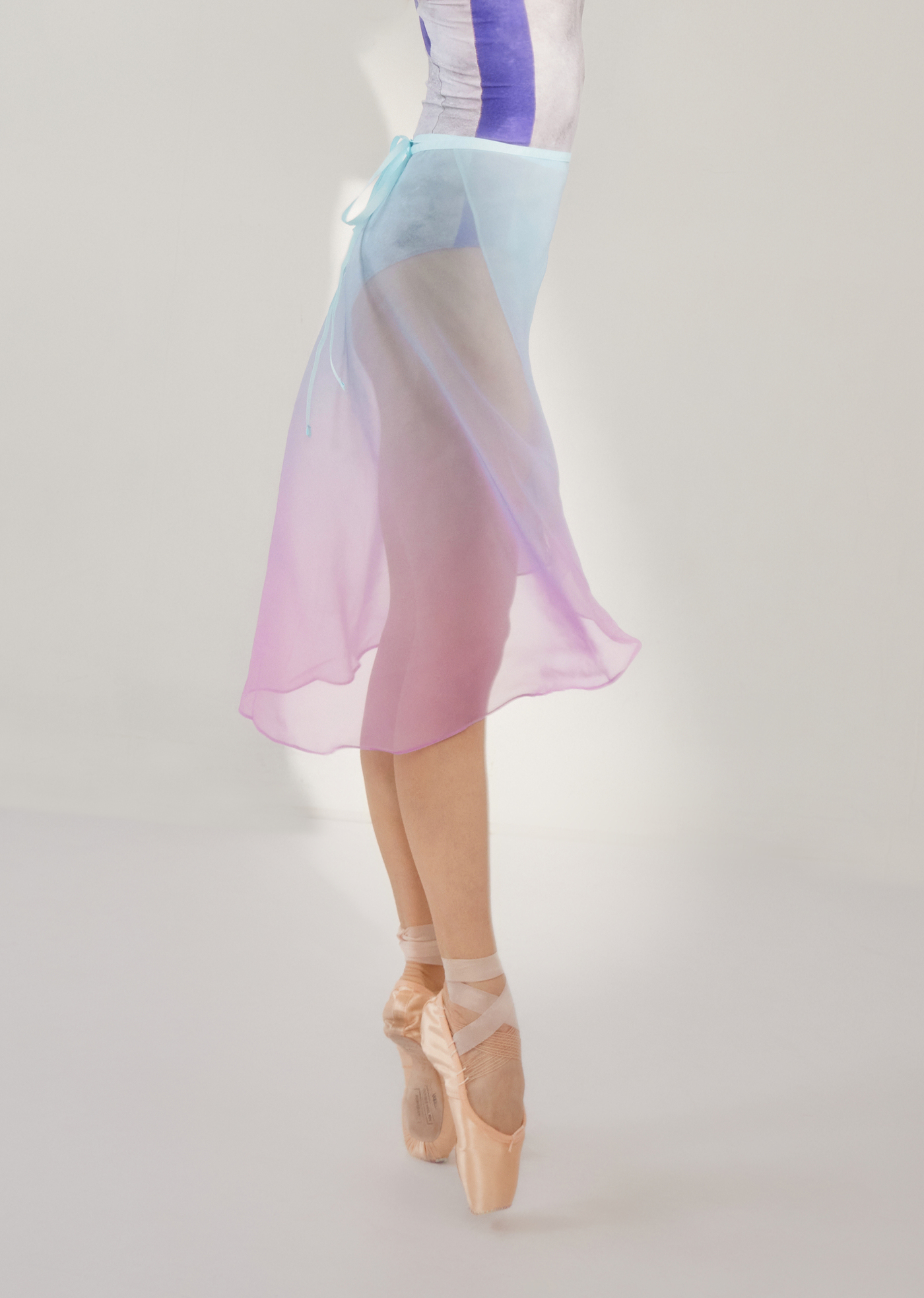 Ballerina in a pastel gradient skirt on a plain background