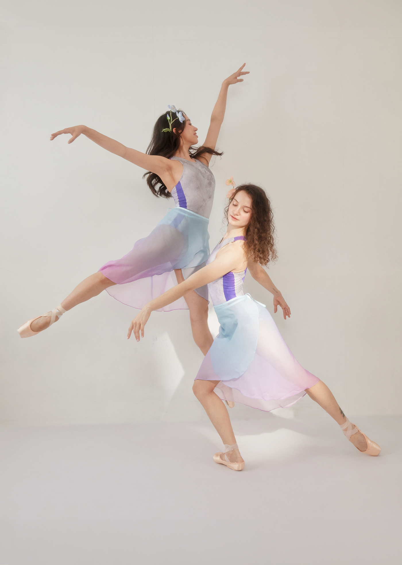 Two dancers in pastel costumes posing against a plain background.