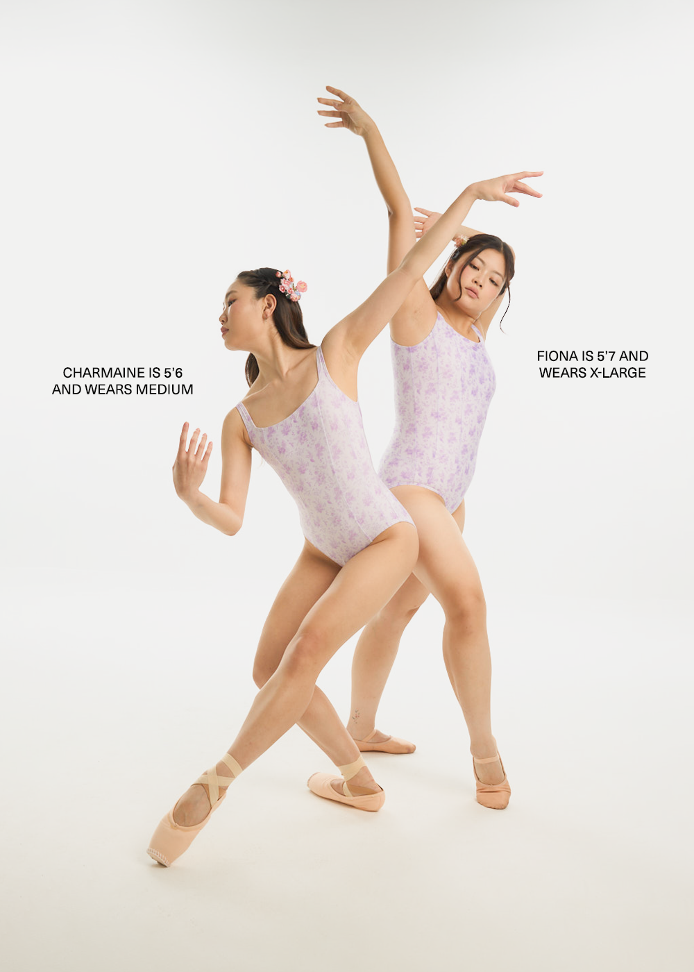 Two dancers in matching lavender leotards posing against a white background